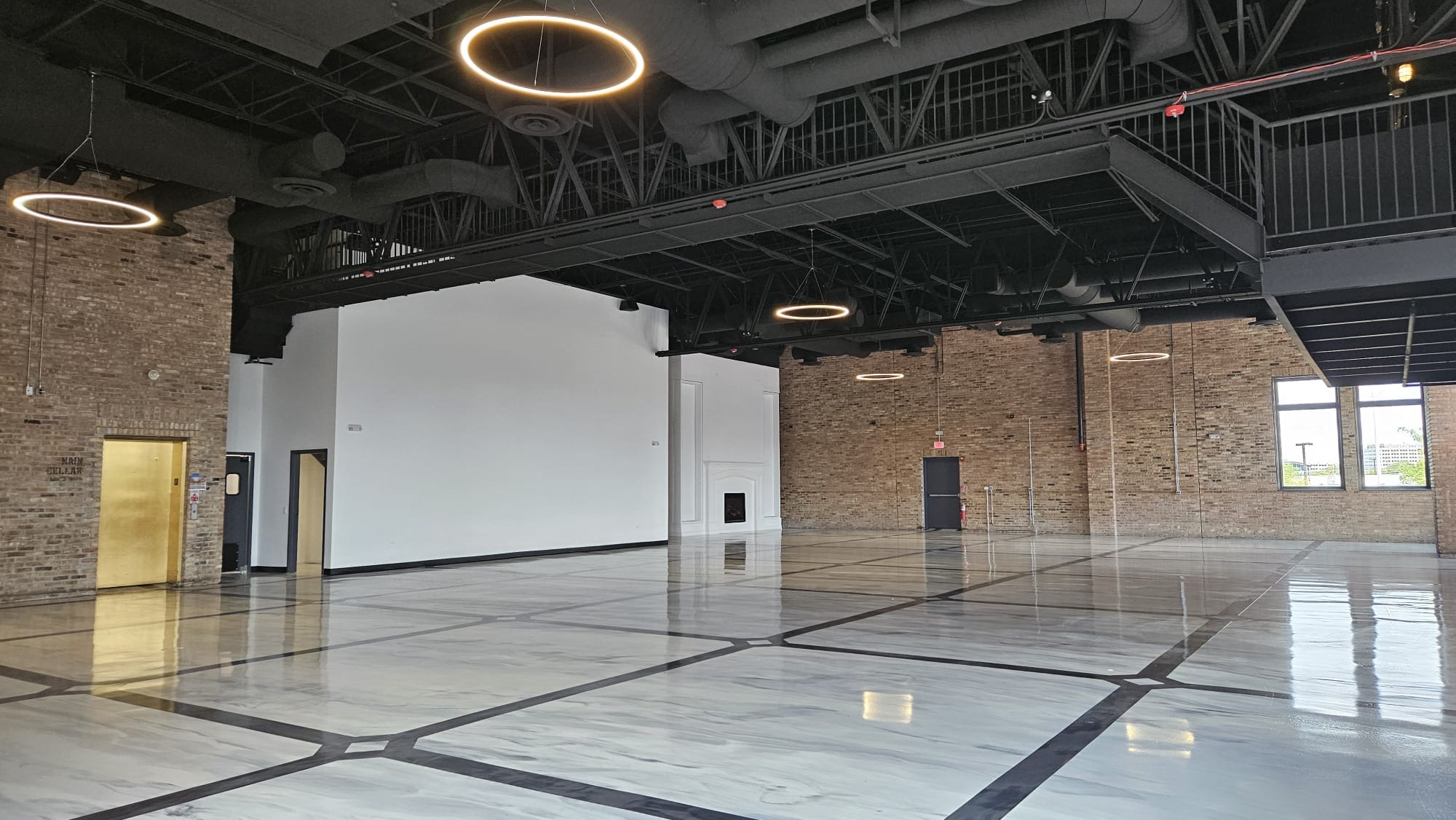 The open hall with mezzanine, ring lights, and marble floors
